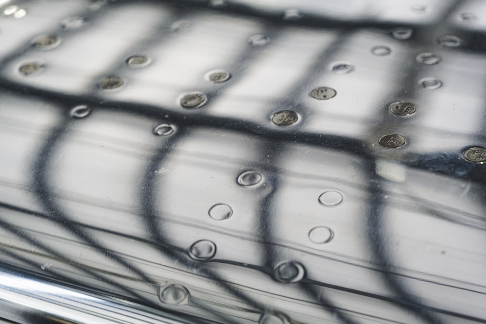 a close up of a metal object with water droplets on it