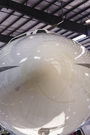 A close-up of an aircraft undergoing inspection at a hangar.
