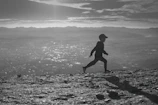A dynamic silhouette of a runner under city lights at night, with deep blue and charcoal tones.