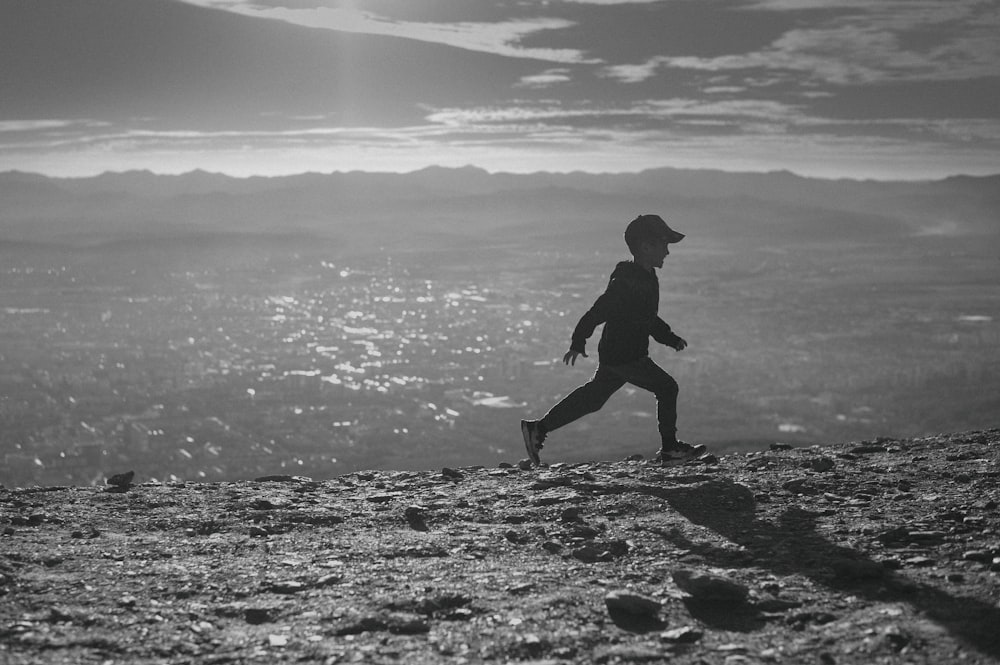 a man running up a hill in the mountains