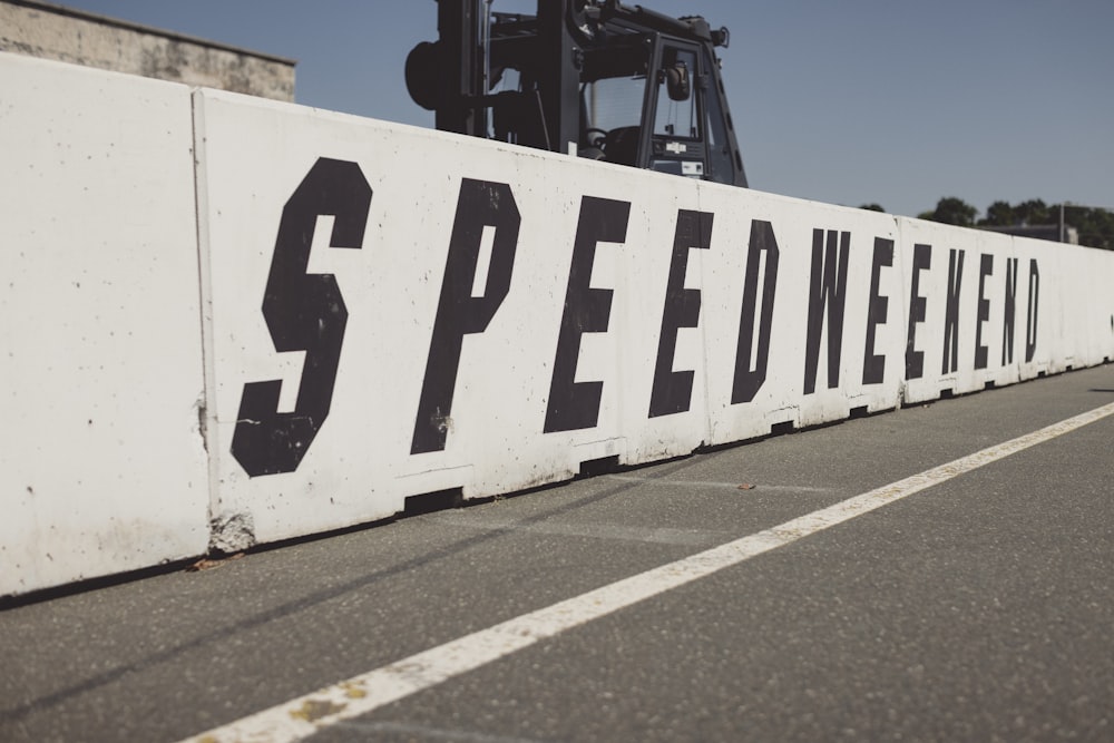 a sign that says speed week on the side of a road