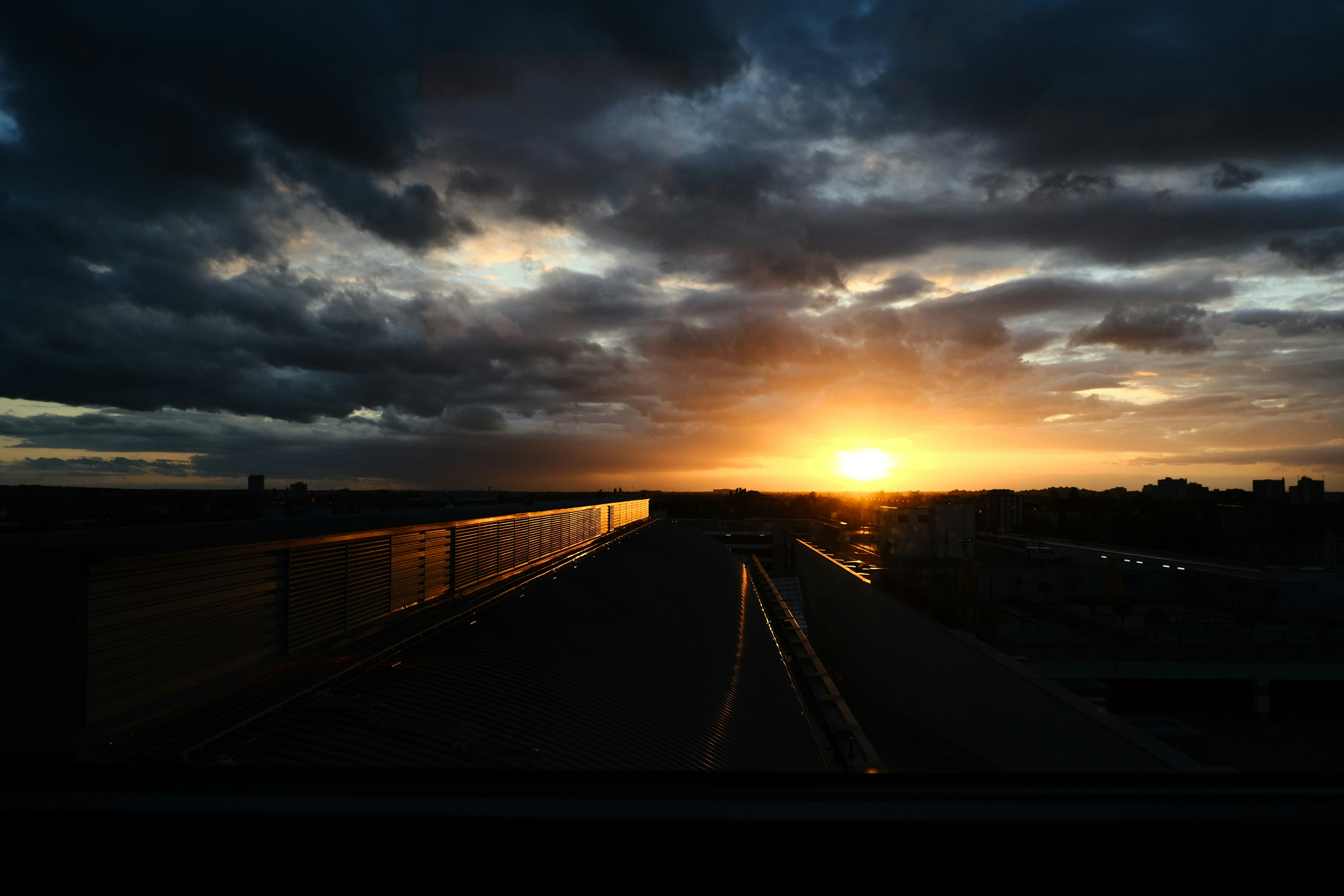 Aerial view of Chicago rooftops at dusk — dramatic golden sky, dense residential neighborhood, warm atmospheric light