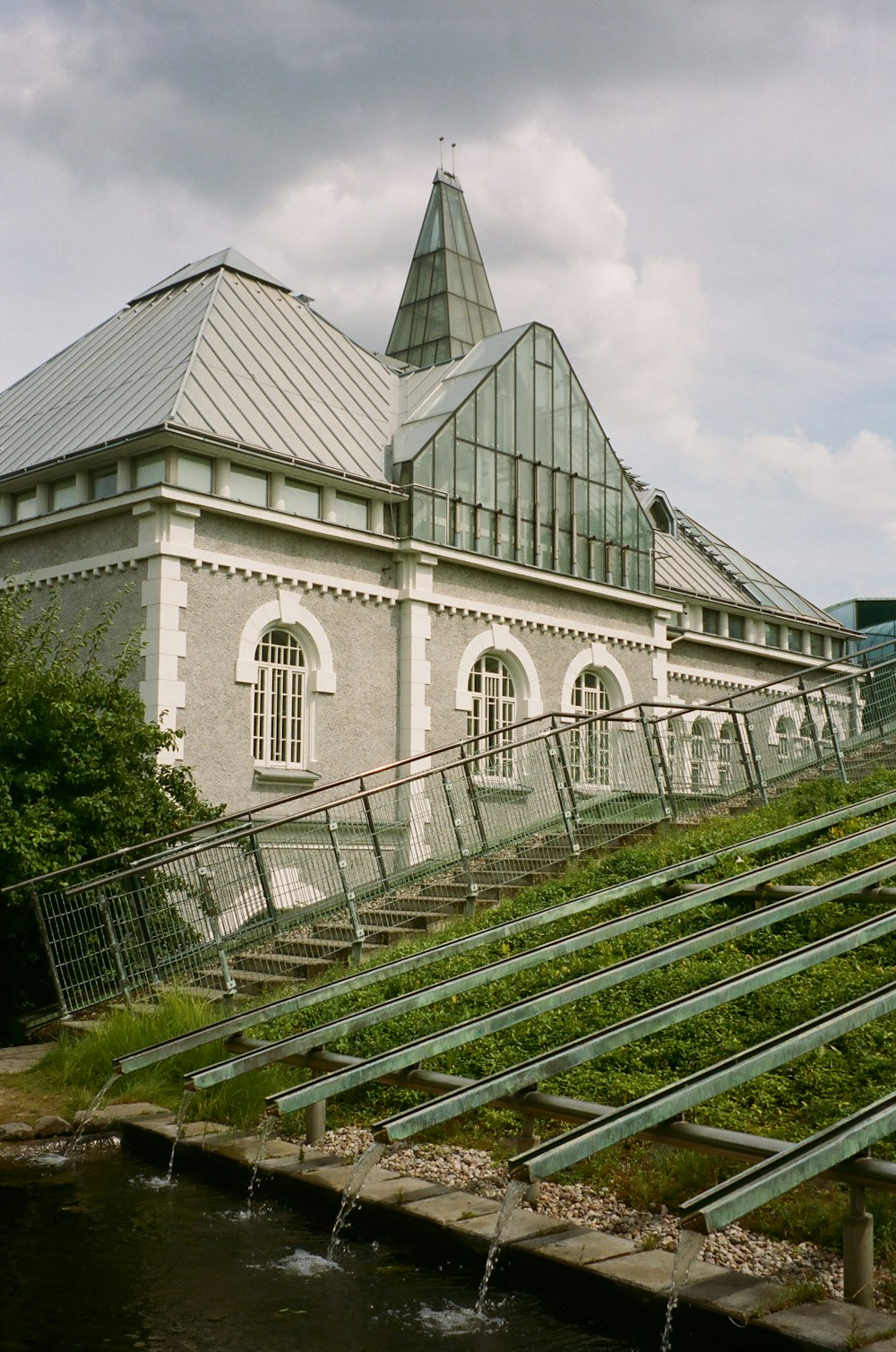 a building with a steeple next to a body of water