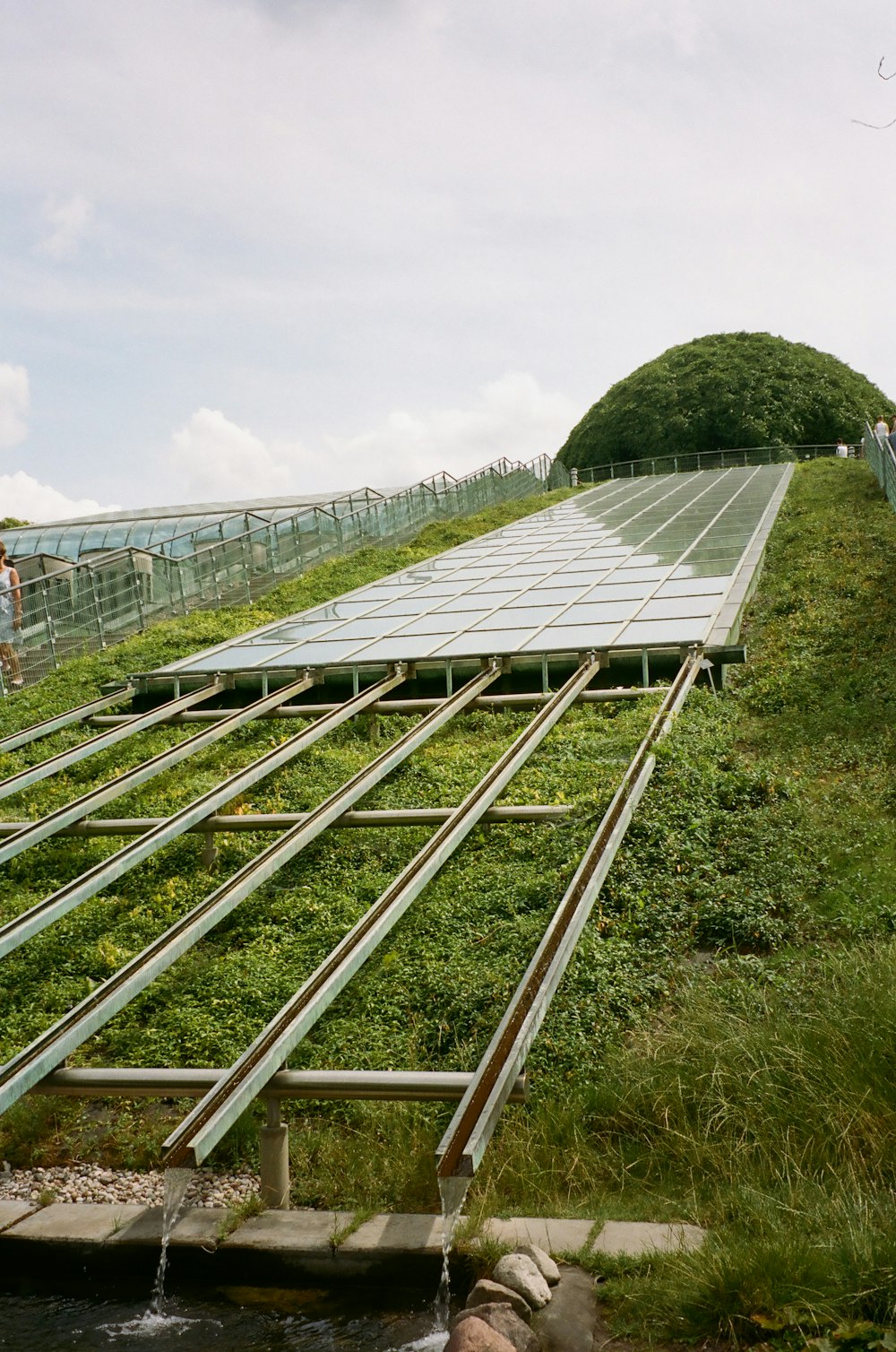 a row of solar panels sitting on top of a lush green hillside