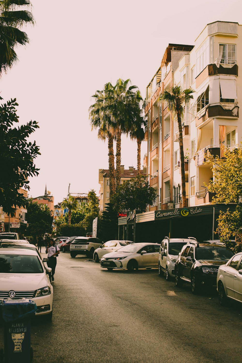 a street filled with lots of parked cars next to tall buildings