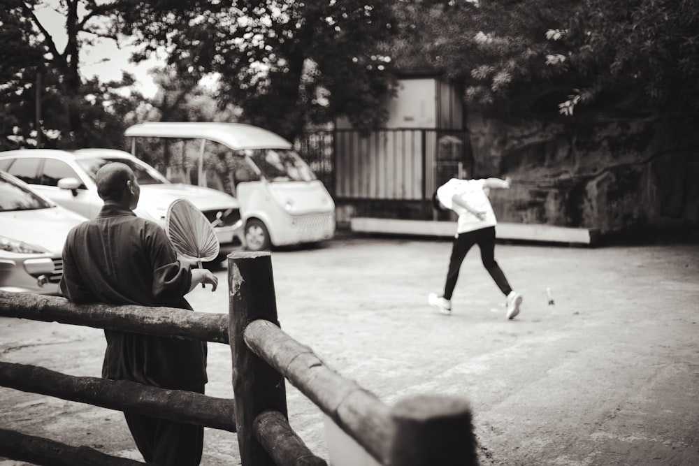 a couple of people that are standing near a fence