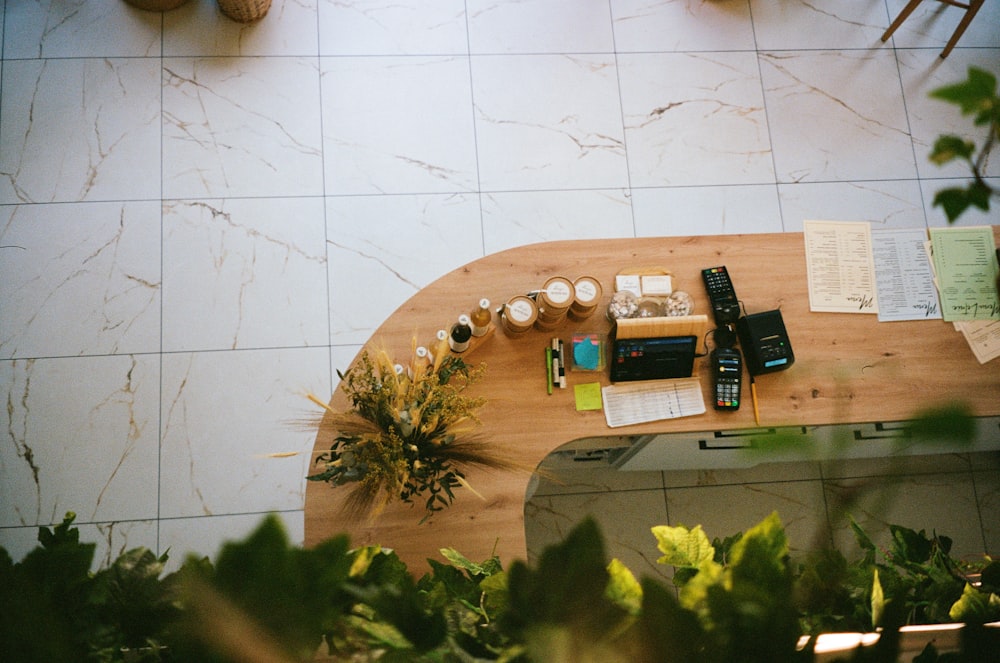 una mesa de madera cubierta con un teléfono celular junto a una planta en maceta