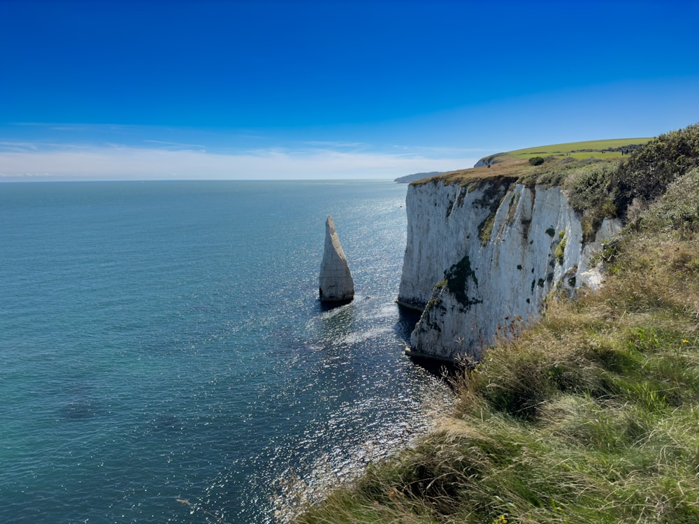 Un bateau est sur l’eau près d’une falaise