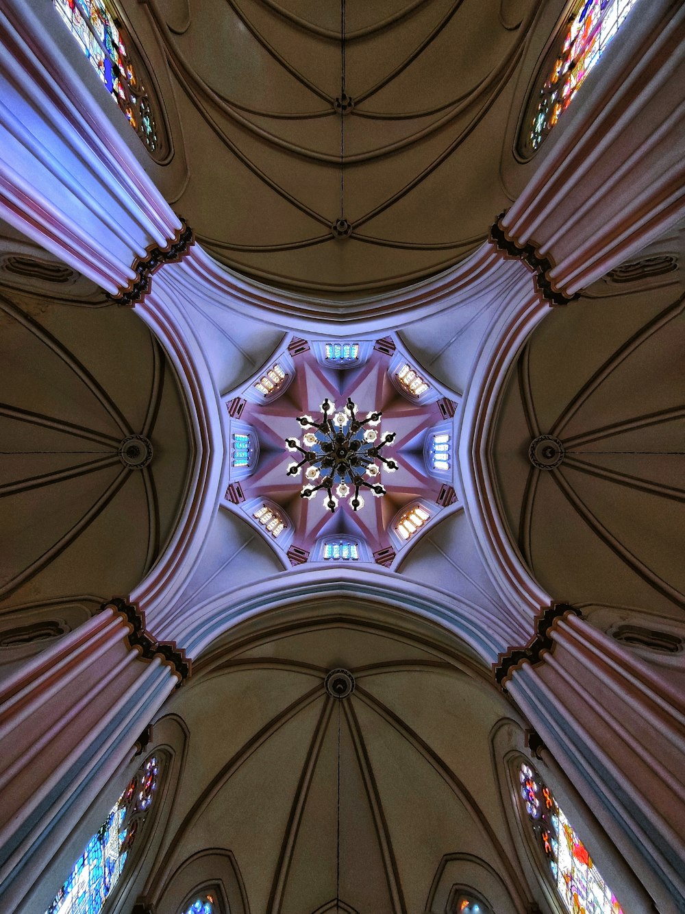 a view of the ceiling of a cathedral with stained glass windows