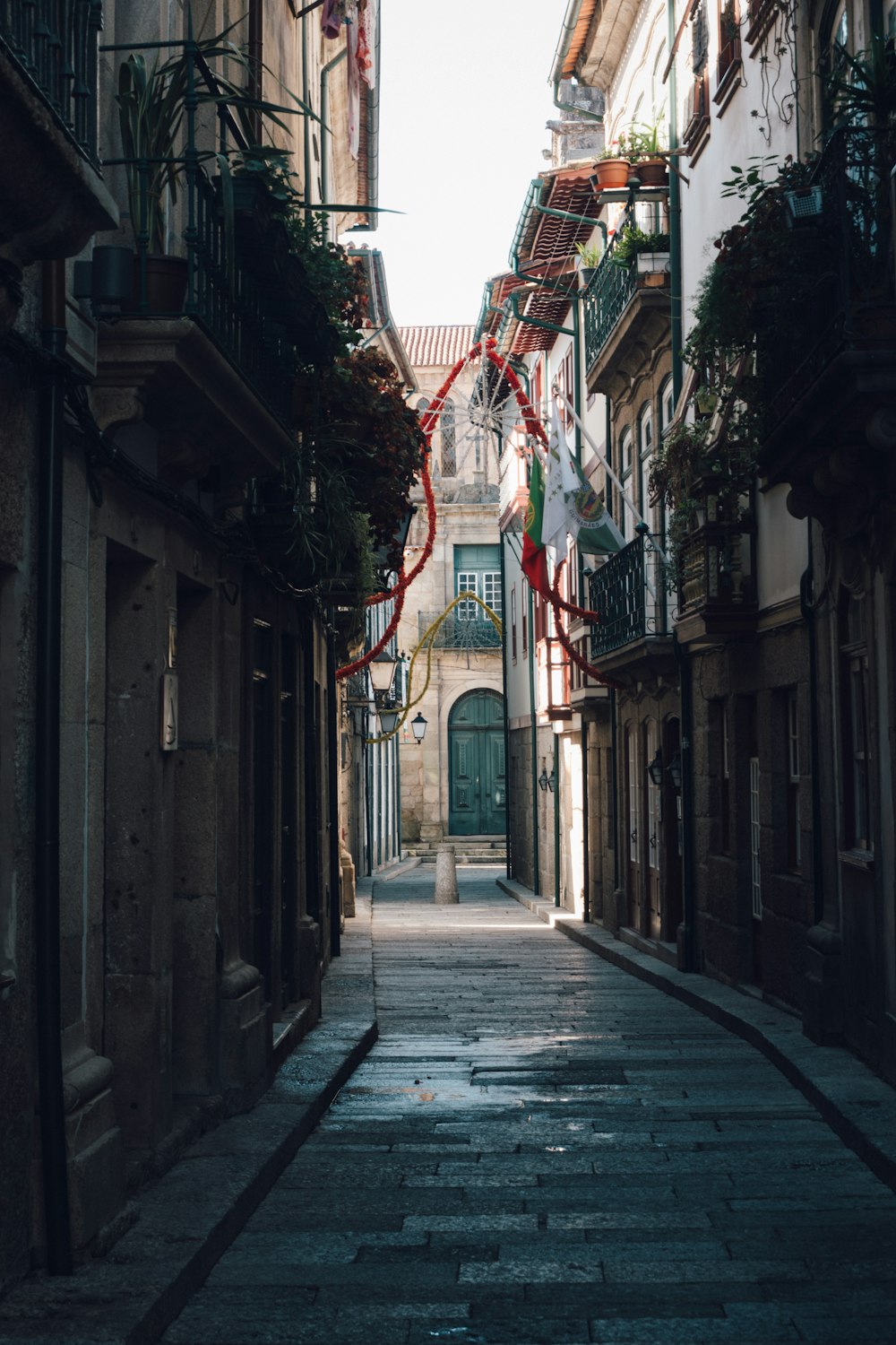 a narrow alleyway with a red ribbon hanging from it