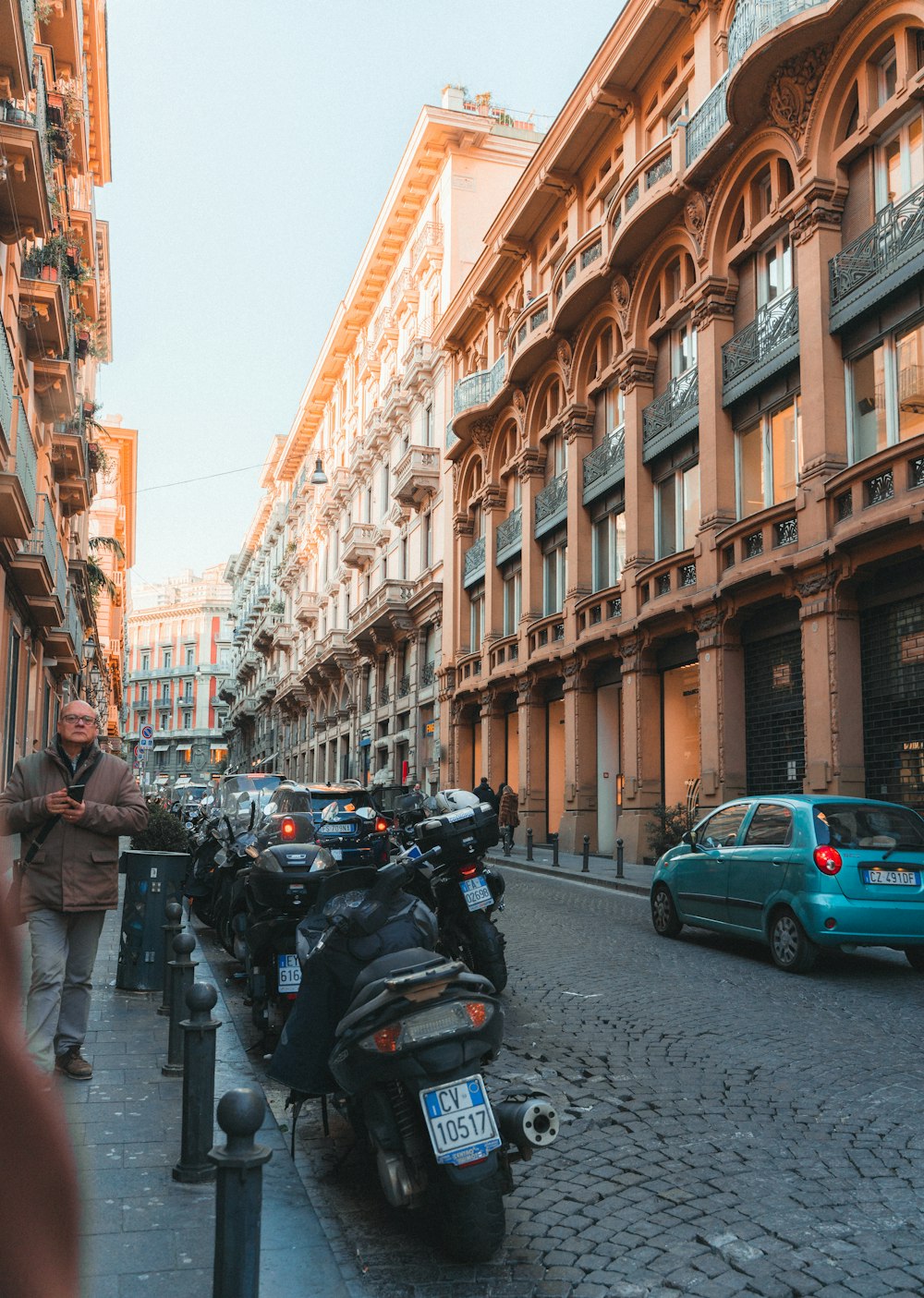 a row of motorcycles parked on the side of a street