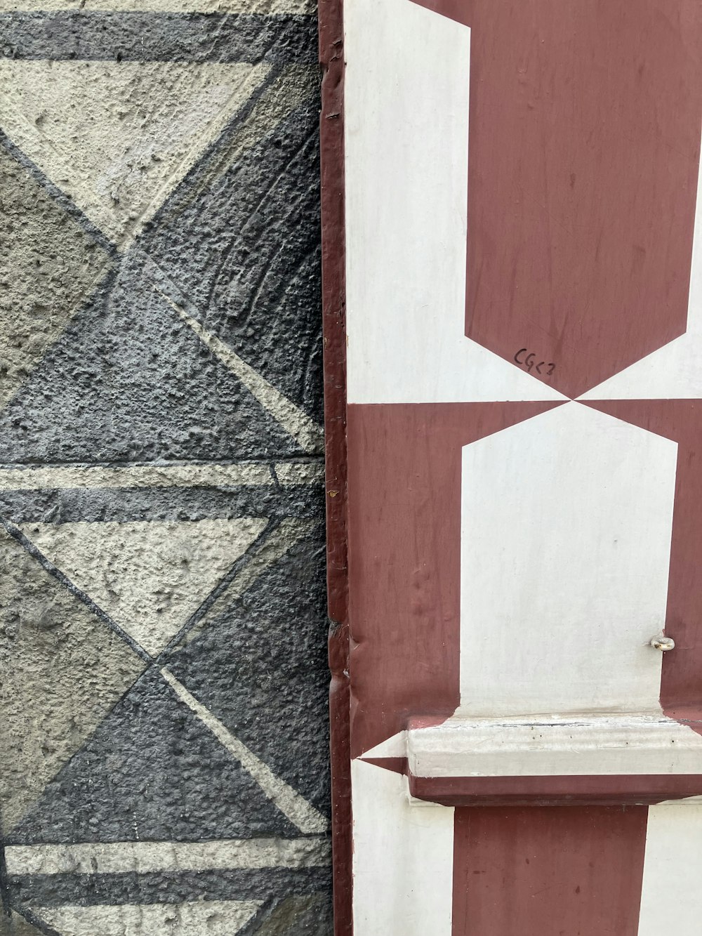 a white bench sitting next to a red and white wall