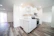 Bright kitchen with crisp white Viking cabinets and a rustic wooden countertop.