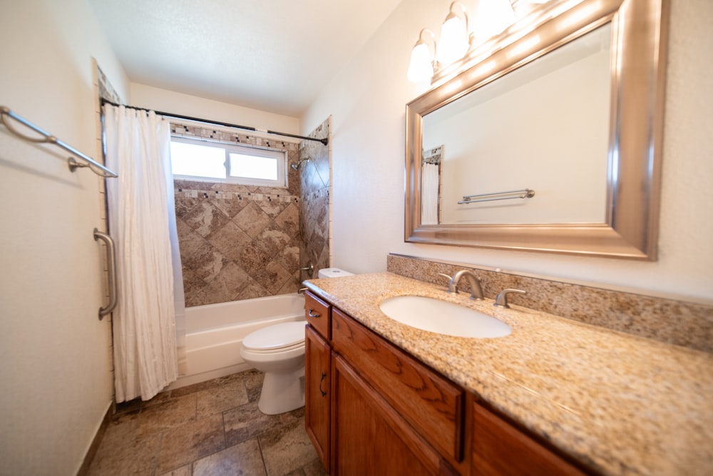 a bathroom with a sink, toilet, and shower