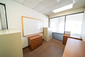 a room with a white board and a wooden cabinet