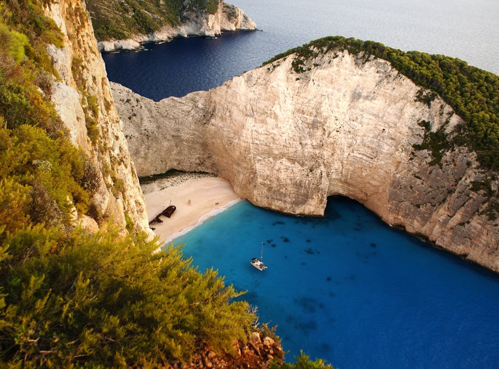 an aerial view of a beach with a boat in the water