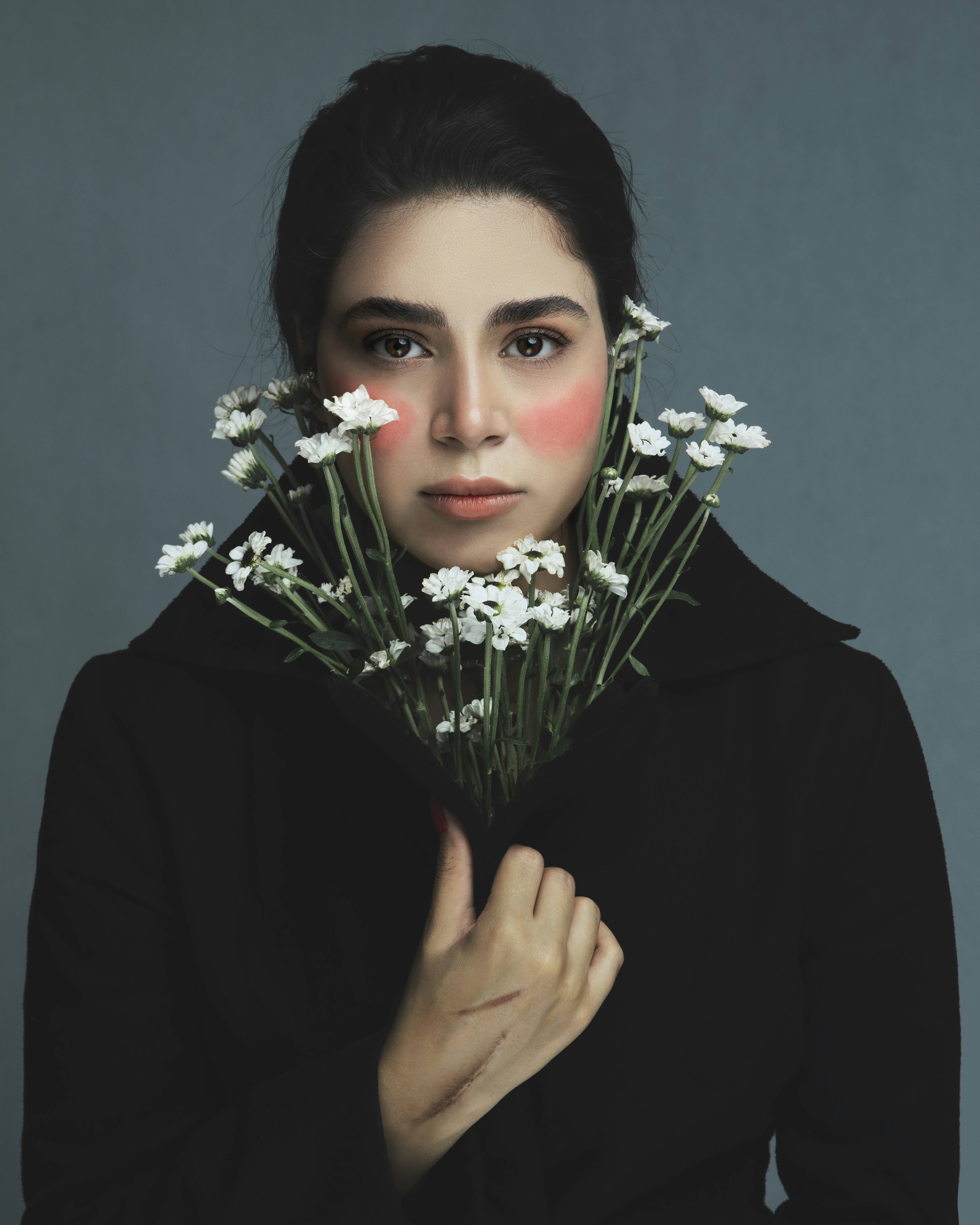 a woman holding a bunch of flowers in front of her face