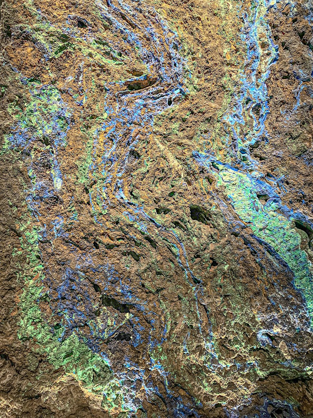 a close up of a rock with blue and green paint