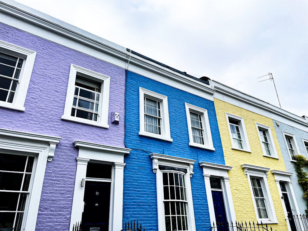 a row of multi - colored houses with white windows