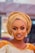 A woman elegantly wearing a colorful headwrap, showcasing a stylish hairstyle with a soft, luxurious texture.