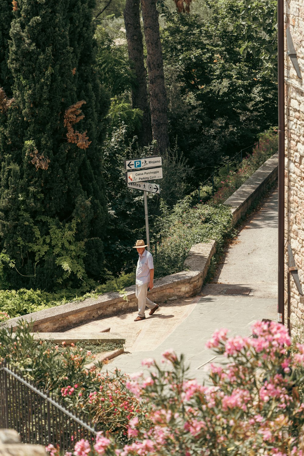 a man standing on a sidewalk next to a street sign