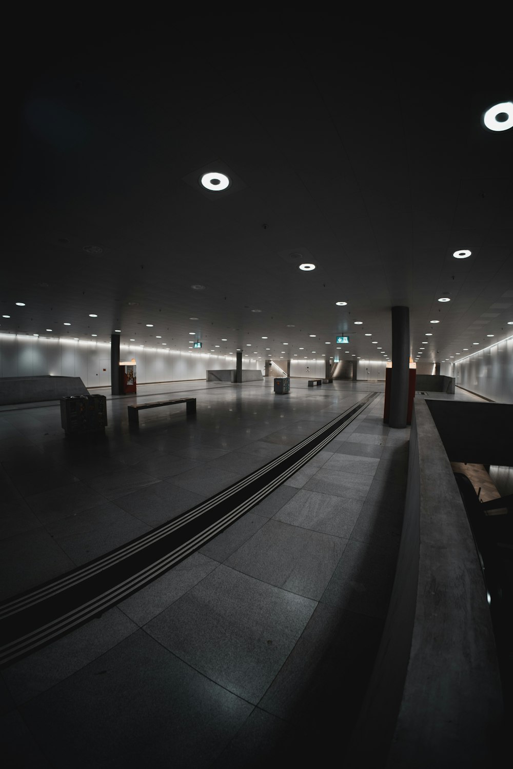 a dimly lit subway station with benches and lights