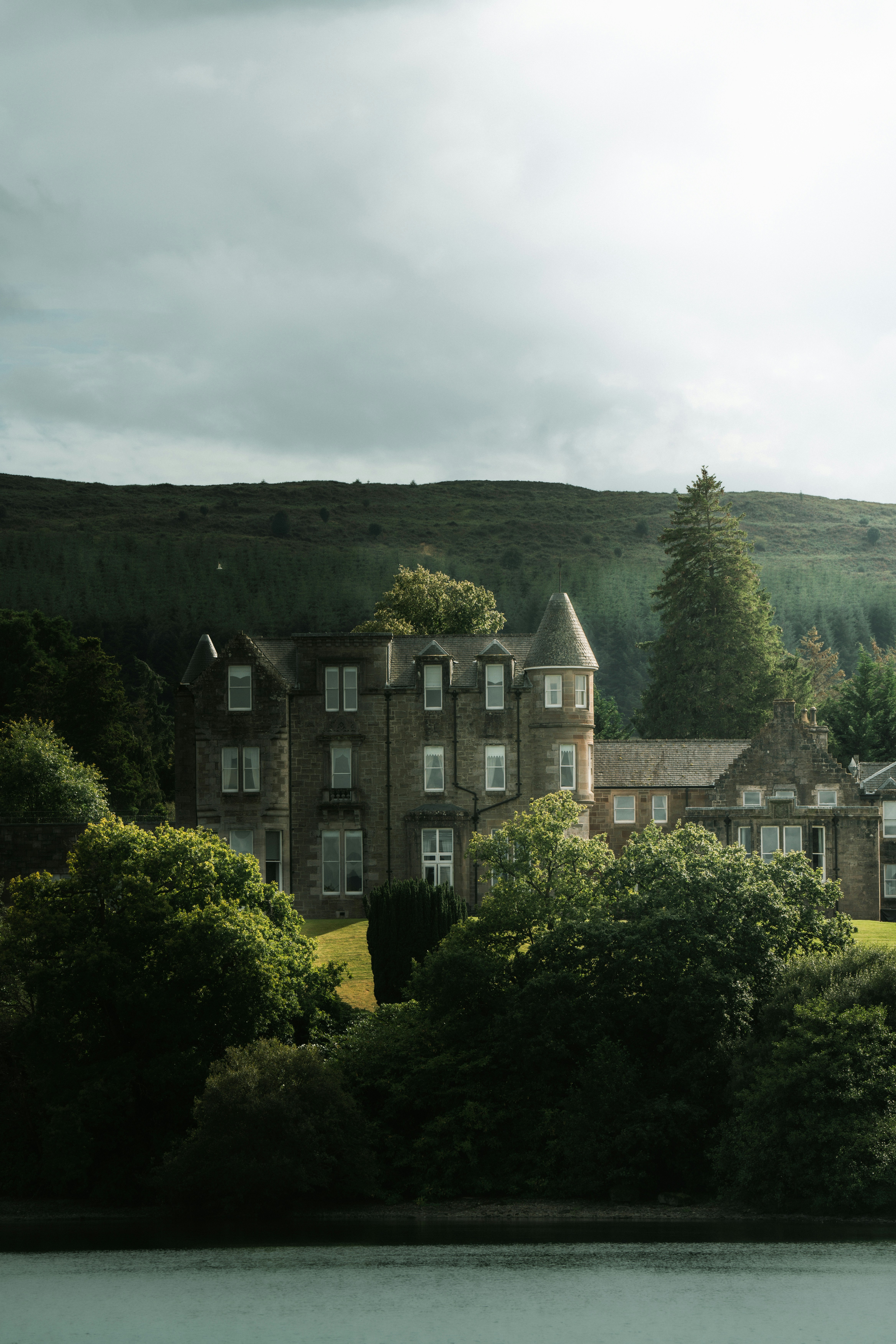 a large building sitting on top of a lush green hillside