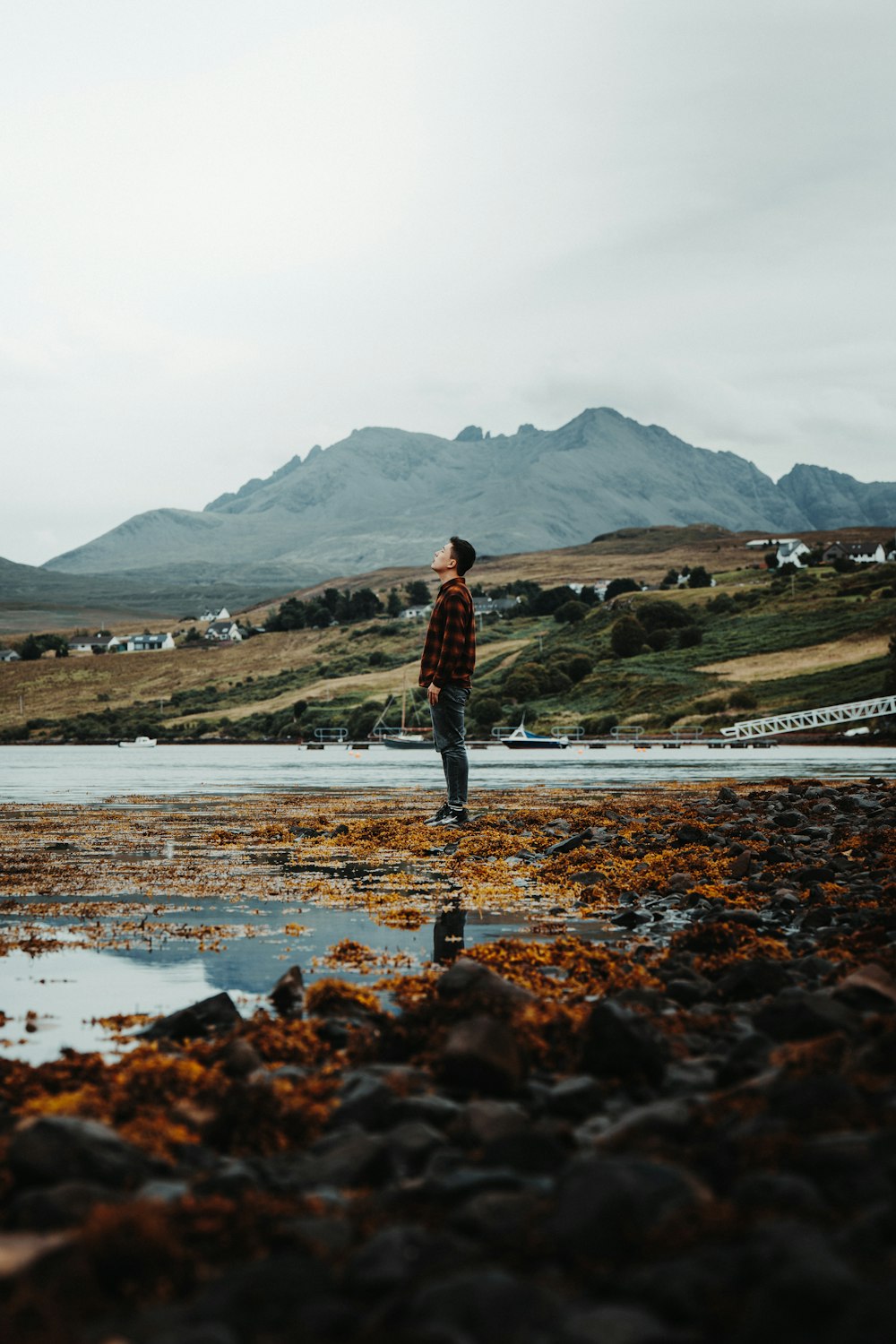 a man standing on a beach next to a body of water