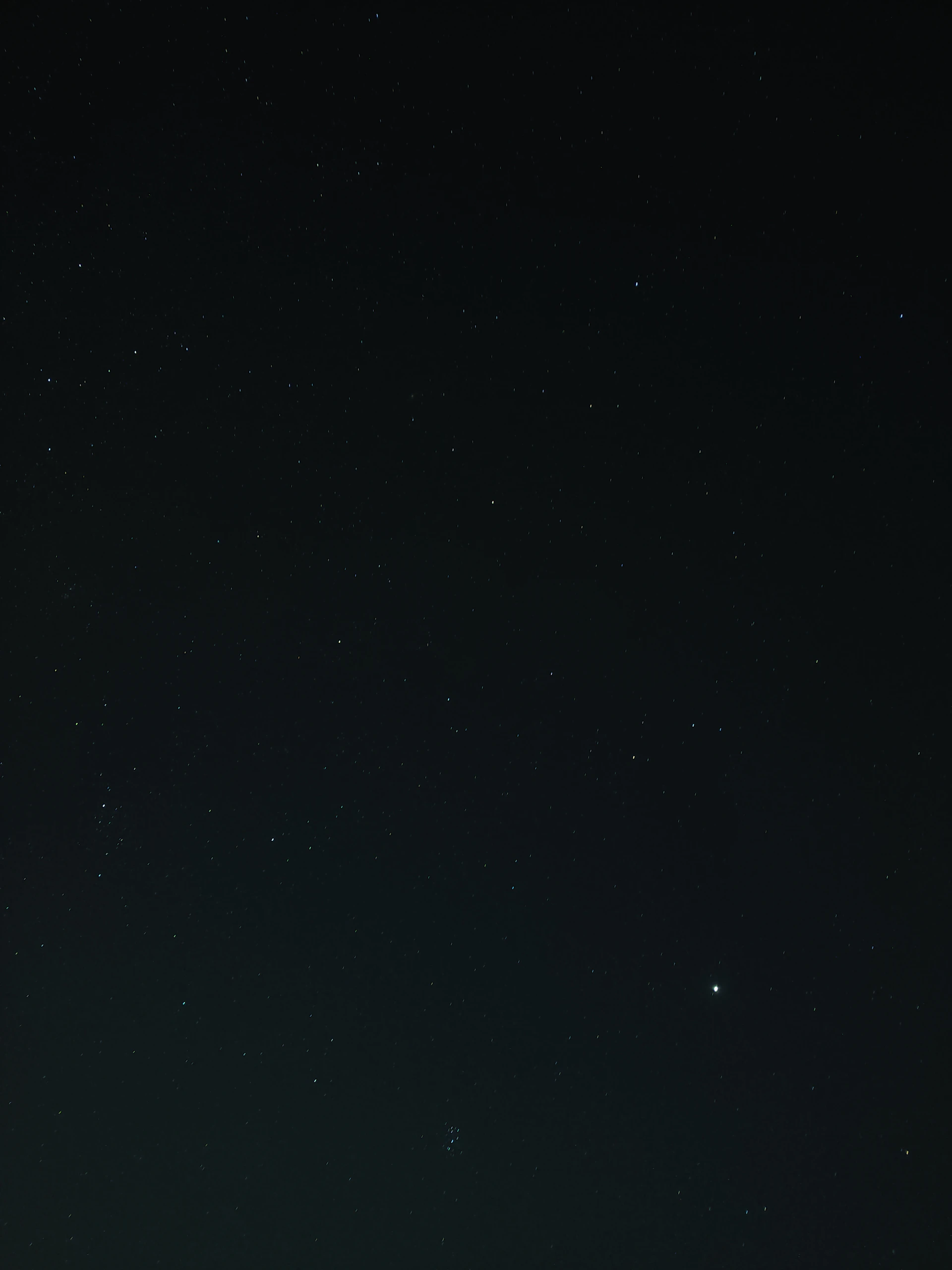 a dark sky with stars and a few clouds