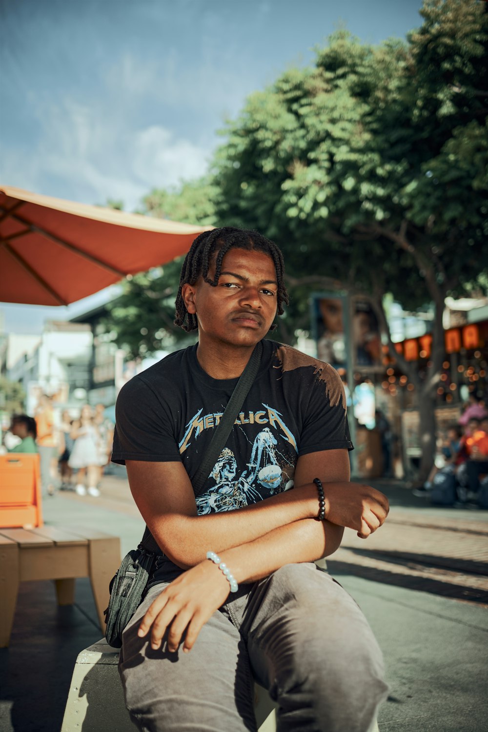 a man sitting on a bench with his arms crossed