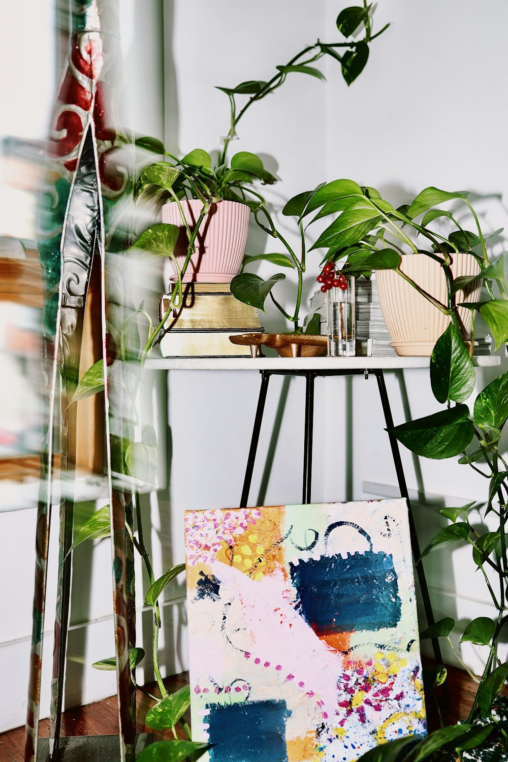 a table with plants and a painting on it