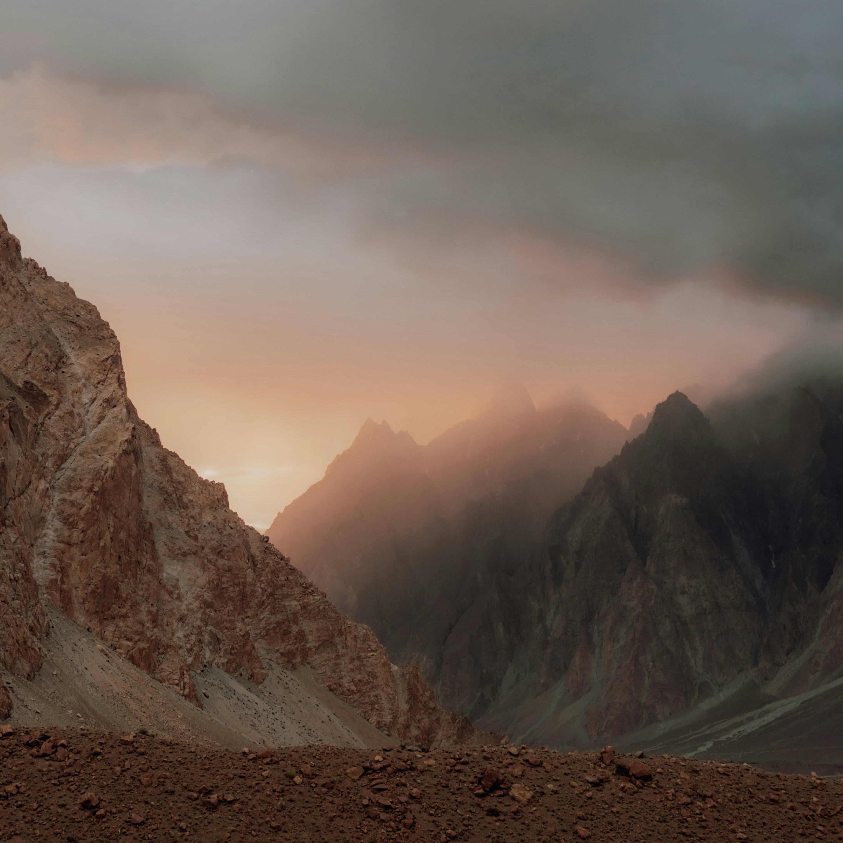 a mountain range with a cloudy sky in the background