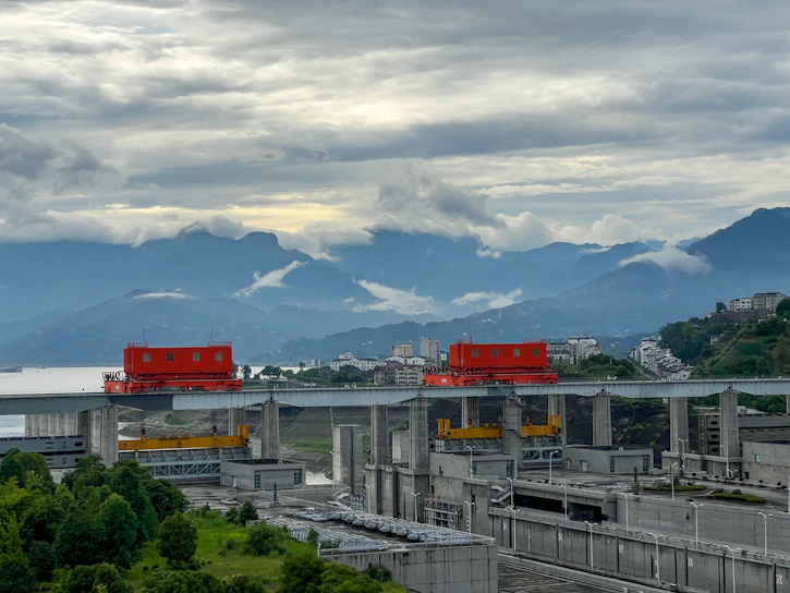 A detailed view of a large hydraulic dam under construction with workers and machinery.