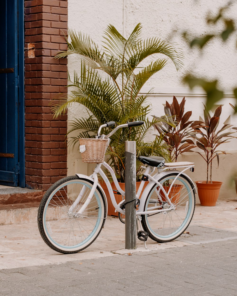 a white bicycle parked on the side of a street