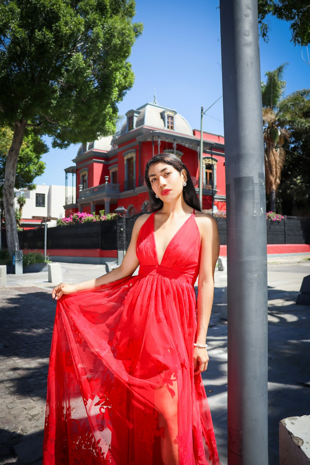 a woman in a red dress is posing for a picture