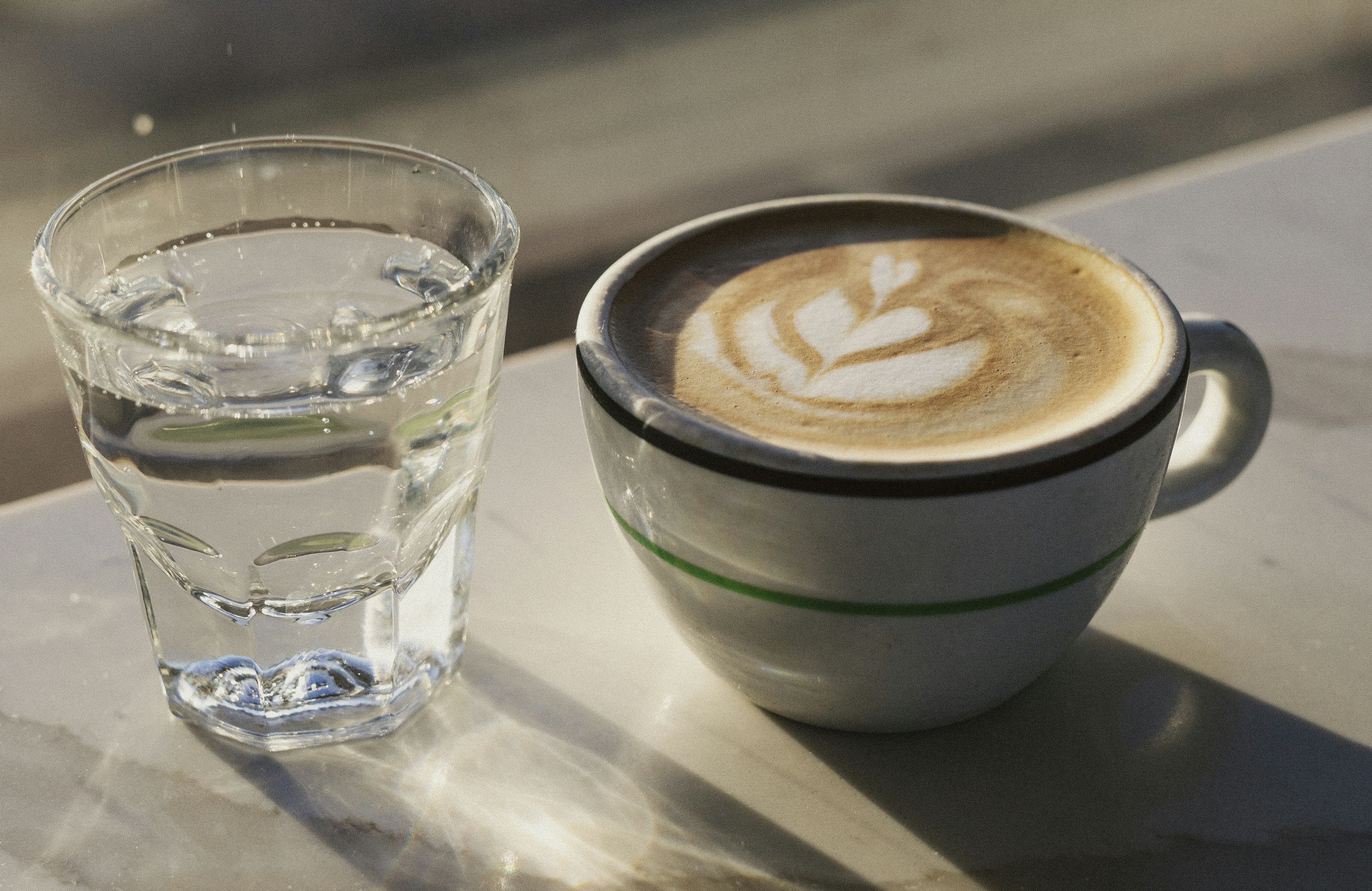 a cup of coffee next to a glass of water