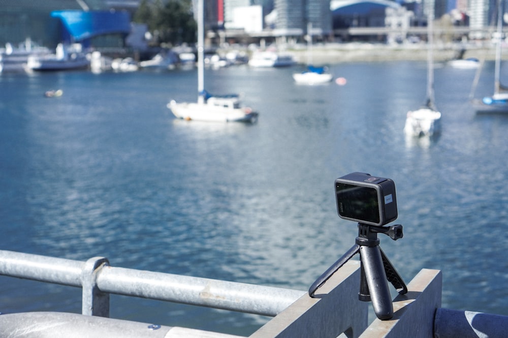 a camera on a tripod on a railing overlooking a body of water