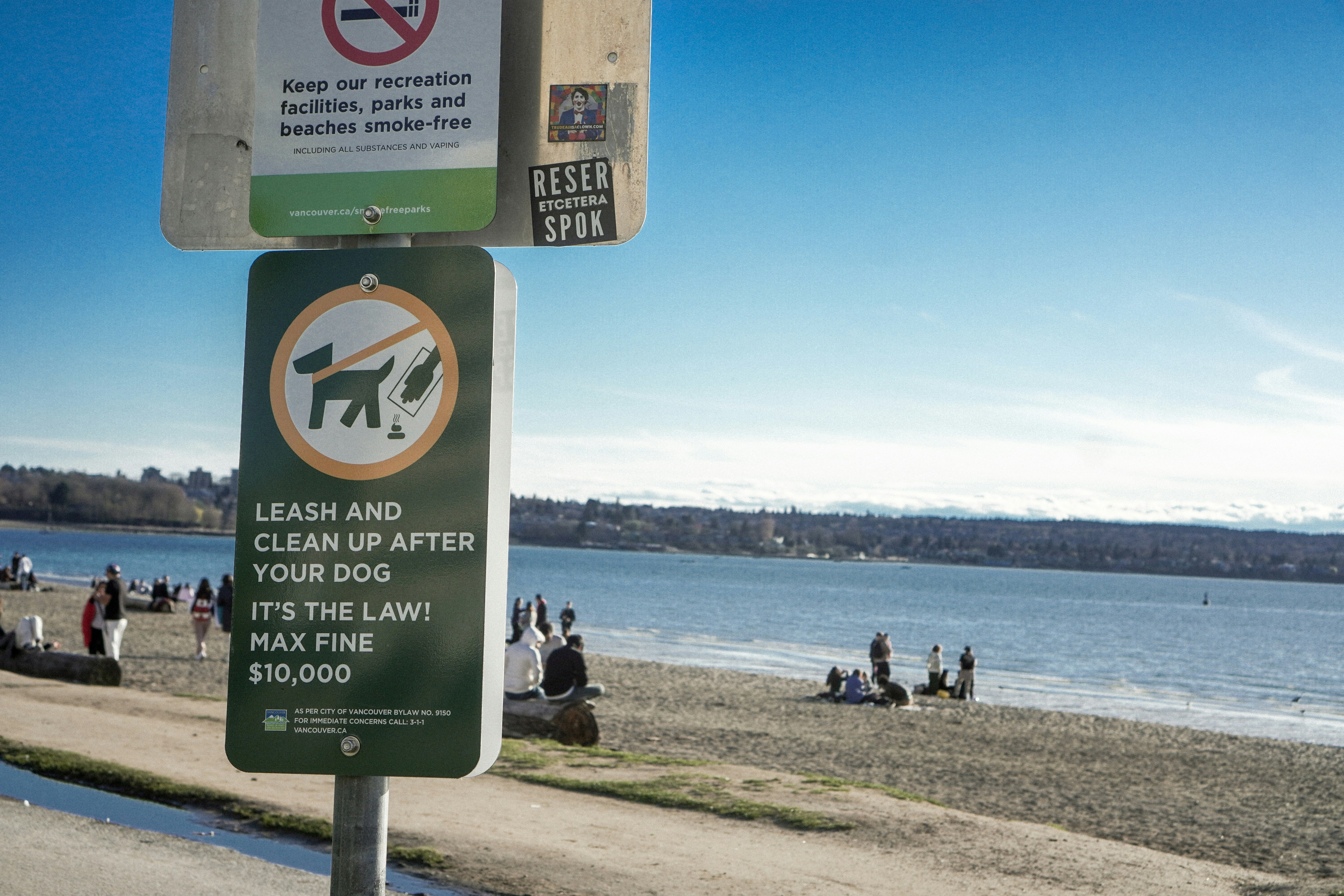 a sign on the side of a road near a beach