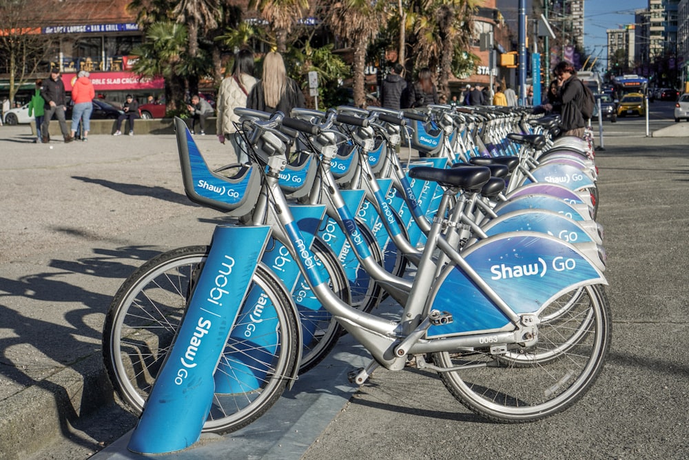 a row of blue bicycles parked next to each other