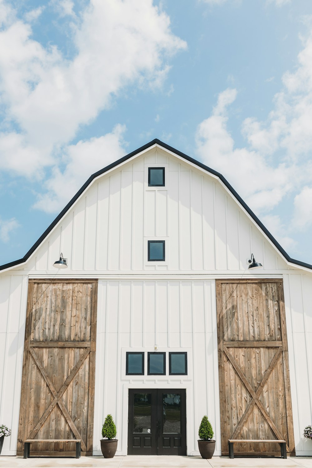 a large white barn with wooden doors and windows