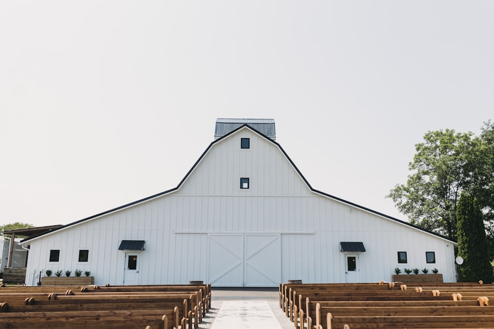 a large white barn with rows of wooden pews