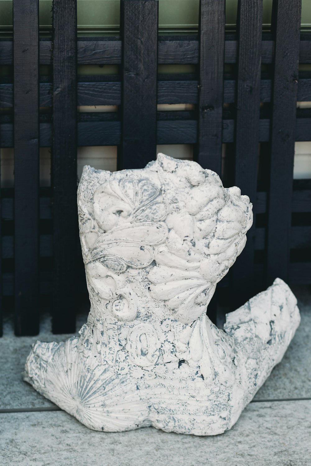 a white statue sitting on top of a sidewalk