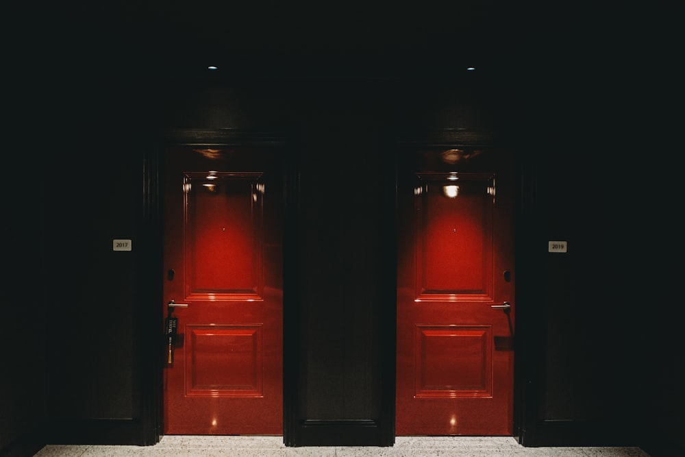 a couple of red doors in a black room
