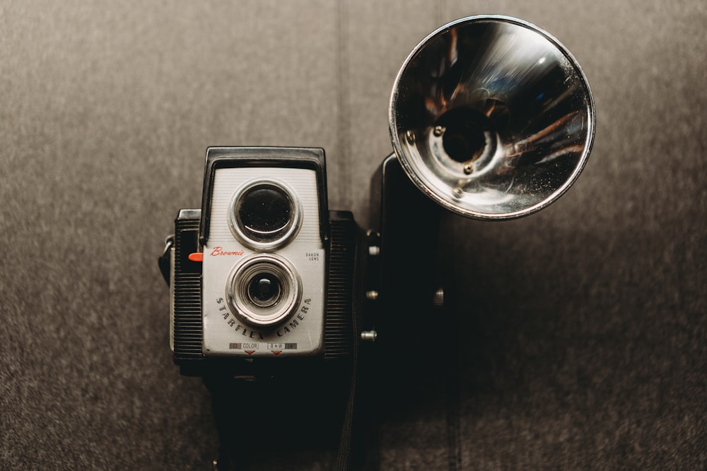 una vecchia macchina fotografica con una campana d'argento sopra