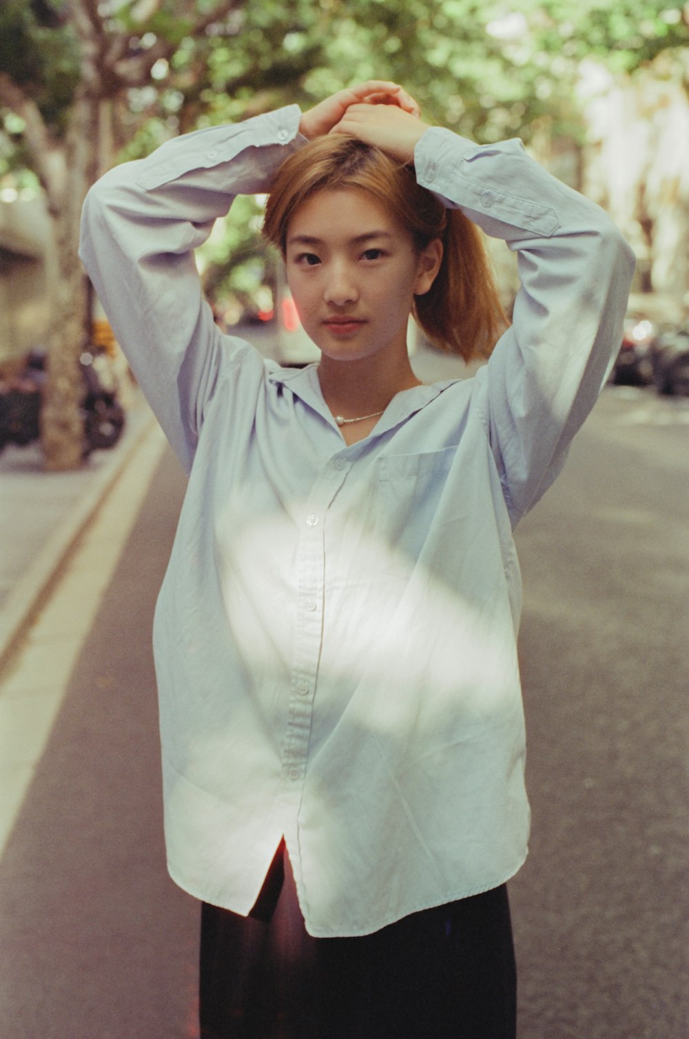 a woman standing on the side of a road