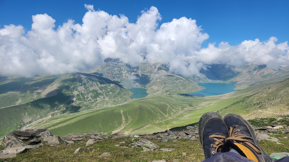 a pair of shoes sitting on top of a lush green hillside