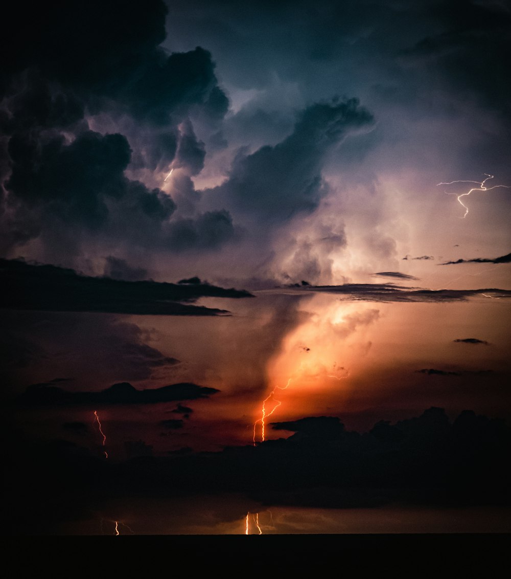 a lightning bolt is seen in the sky above a body of water
