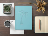 A neatly arranged desk with a journal, a cup of herbal tea, and a delicate green succulent.