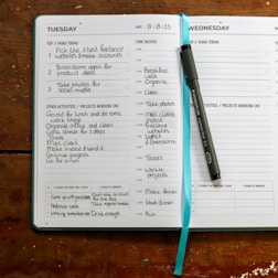 a planner with a pen on top of it