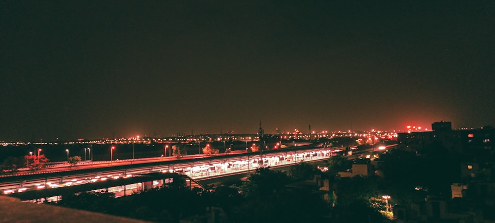 a city at night with a train on the tracks